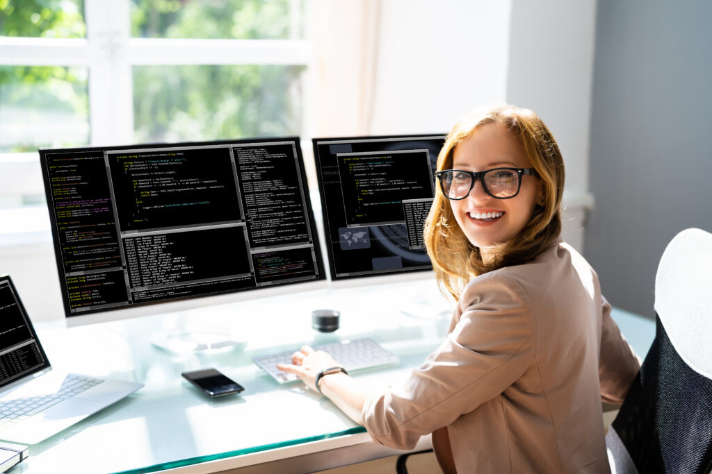 Female Programmer Coding On Computer.