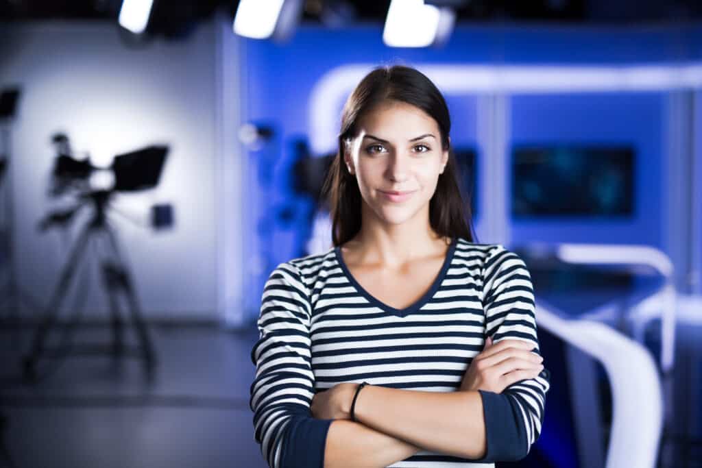 Young woman television announcer at studio standing